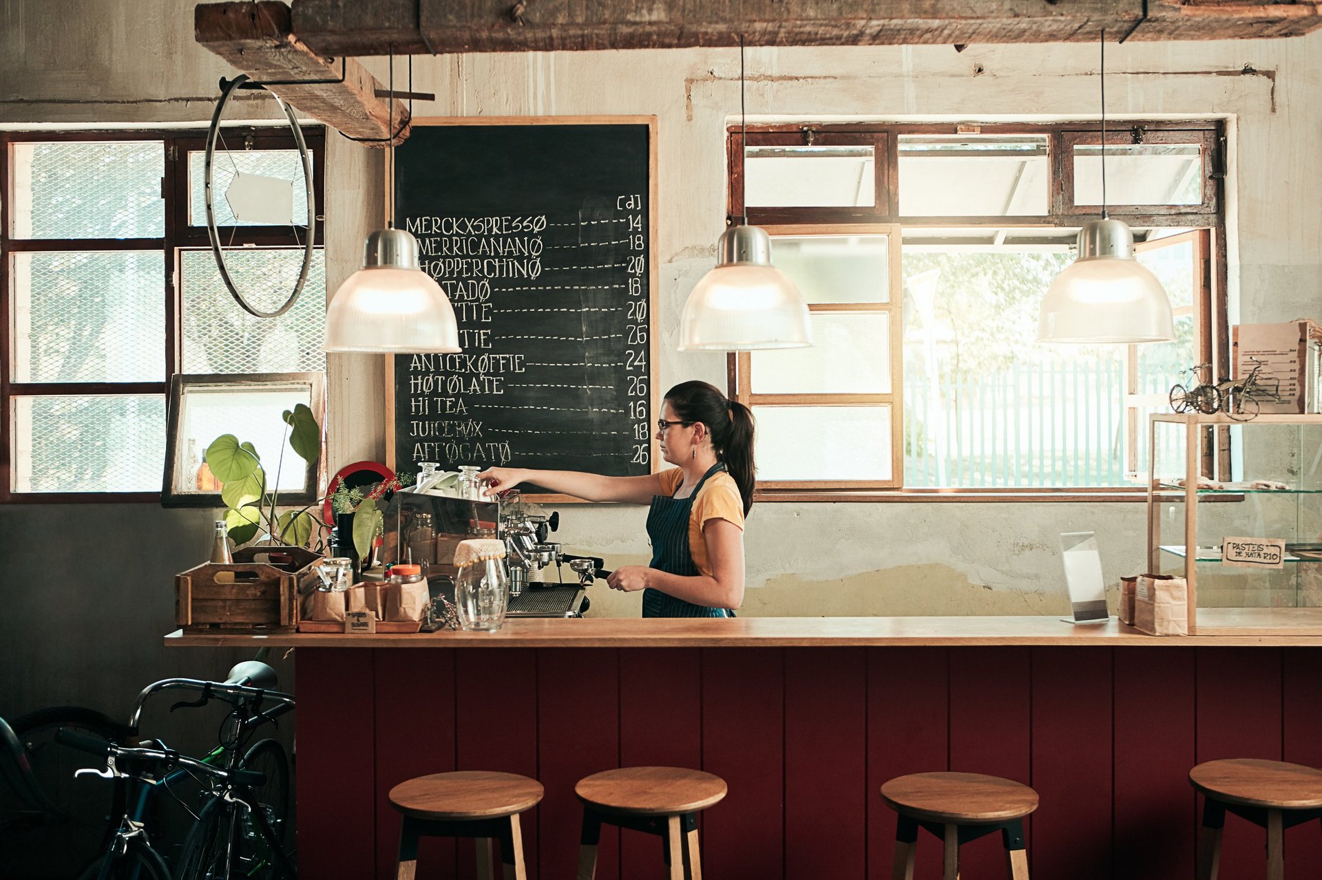 Shot of a young barista working in her coffee shop